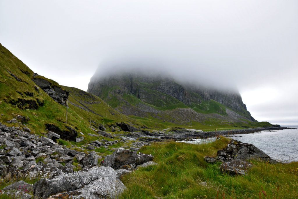 Lofoty, wyspa Vaeroy, trekking szlak. Szlak do na wpół opuszczonego Måstad biegnie cały czas wzdłuż skalistego wybrzeża. Na Værøy niestety piękno surowych gór często znika za gęstymi chmurami. 